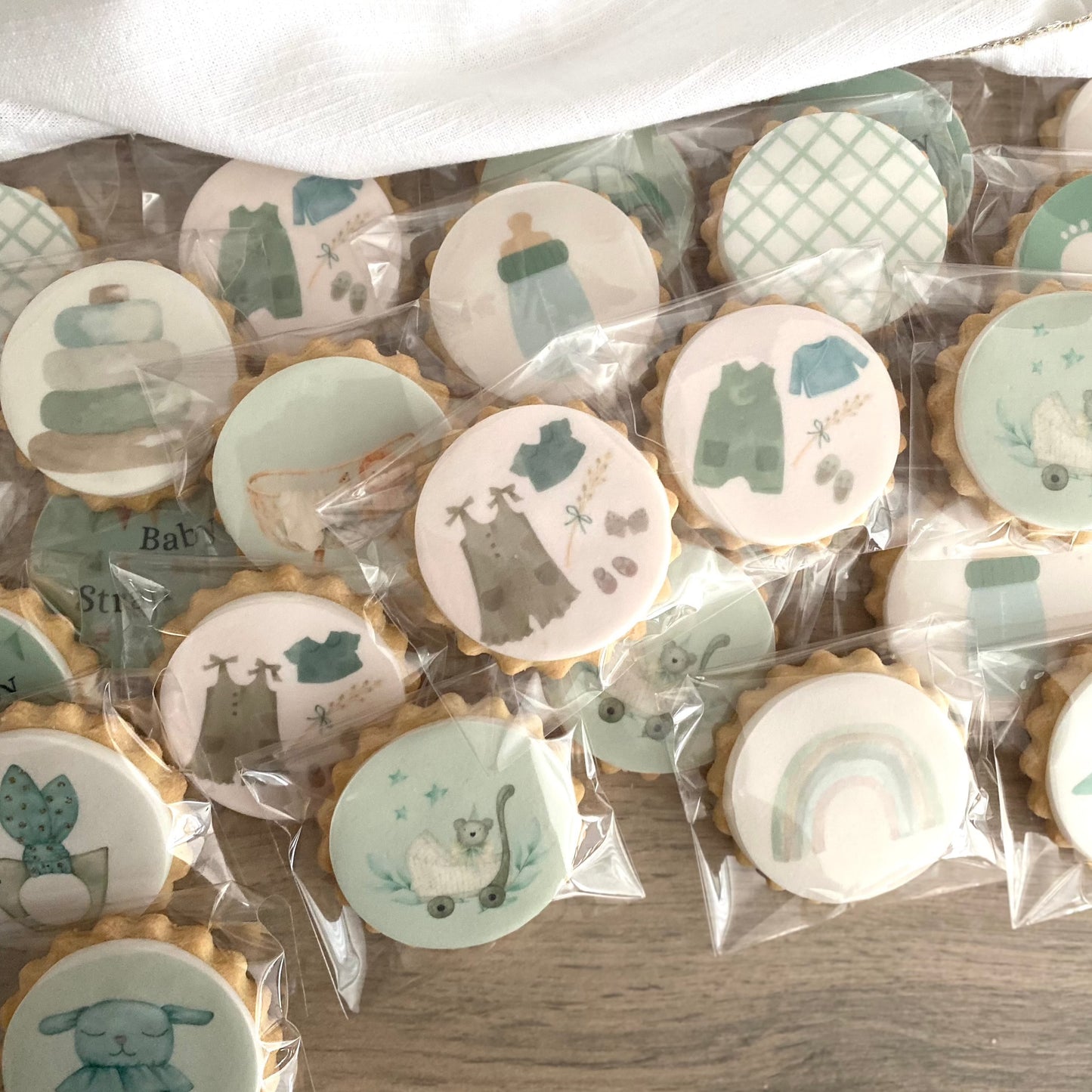 Beautifully decorated baby shower biscuits in pastel and neutral colours - baby shower gifts