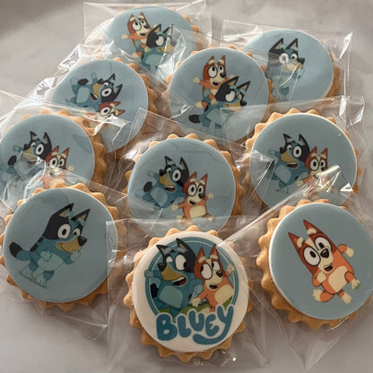 Bluey character biscuits at a fun-filled birthday party - Assorted Bluey and friends character biscuits displayed on a colorful party table